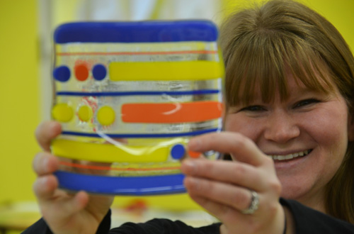 Crystal Elliott holds one of the glass fused pieces at Brushstrokes. With glass fusing, glass plates and strings of glass are melted in a design and then can be bent with curves. Before the business opened, Mrs. Elliott worked on Brushstrokes for about 2 1/2 years, wanting to give families an activity they can do together. She completed a small business class through the Orleans Economic Development Agency.