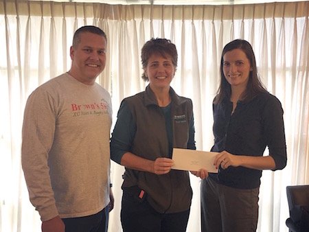 Brian Krieger, executive director of the Albion Running Club, and Margy Brown (center) present a check for $5,708.83 to Hospice of Orleans Development Coordinator Brittany Dix.