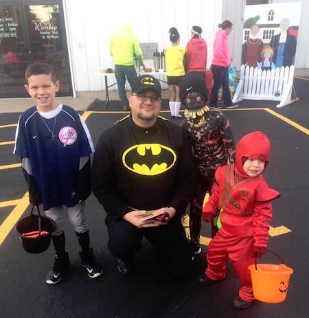 Provided photo: The Rev. Randy LeBaron, with Batman hat and shirt, poses for a picture with kids at the Albion Free Methodist Church on Friday. About 400 kids stopped by the church during Beggar’s Night for games and candy.
