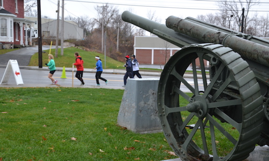 Runners pass by State Street Park and the war memorial.