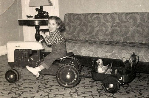 The book includes many pictures of “farm kids,” including this one of Holly Ricci as a girl on a pedal tractor.