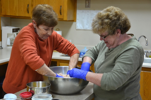 Mary Ellen Seaman and Kathy Scroger work together on making the Hardenbrook family ham loaf at the Morton Baptist Church.
